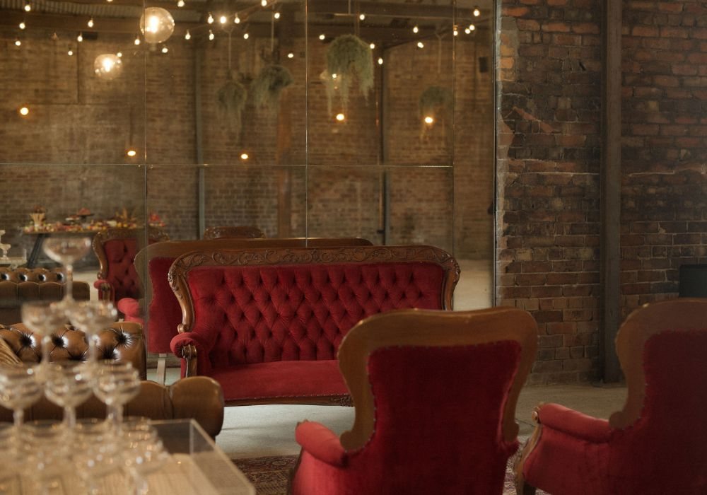 Red velvet lounges and a coupe tower against the brick wall