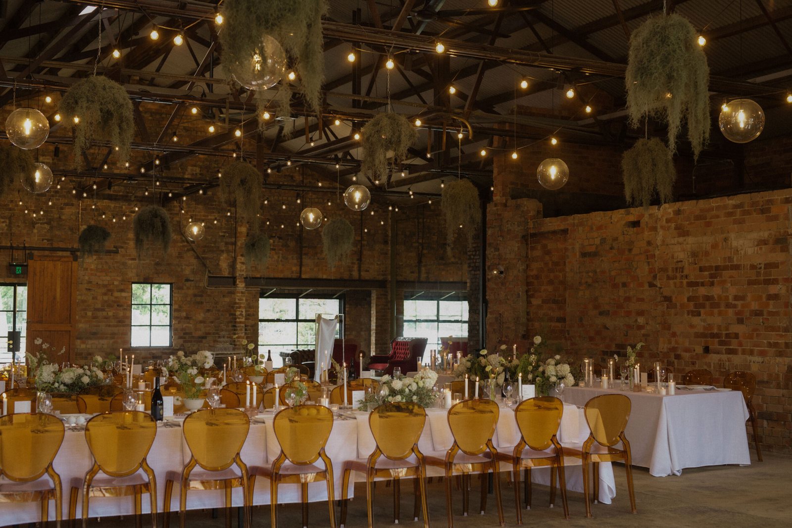 The Truck Room set for dinner with white linen and amber chairs under festoon lights